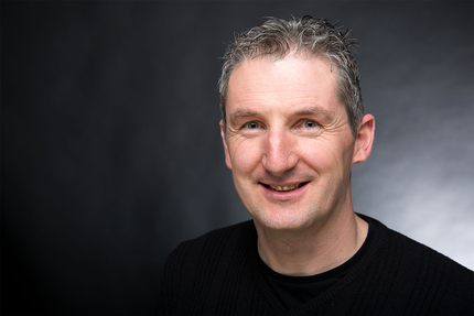 Portrait di Martin Kargruber, collaboratore per preventivi e contabilità edile e gare pubbliche presso Kargruber-Stoll, davanti uno sfondo grigio